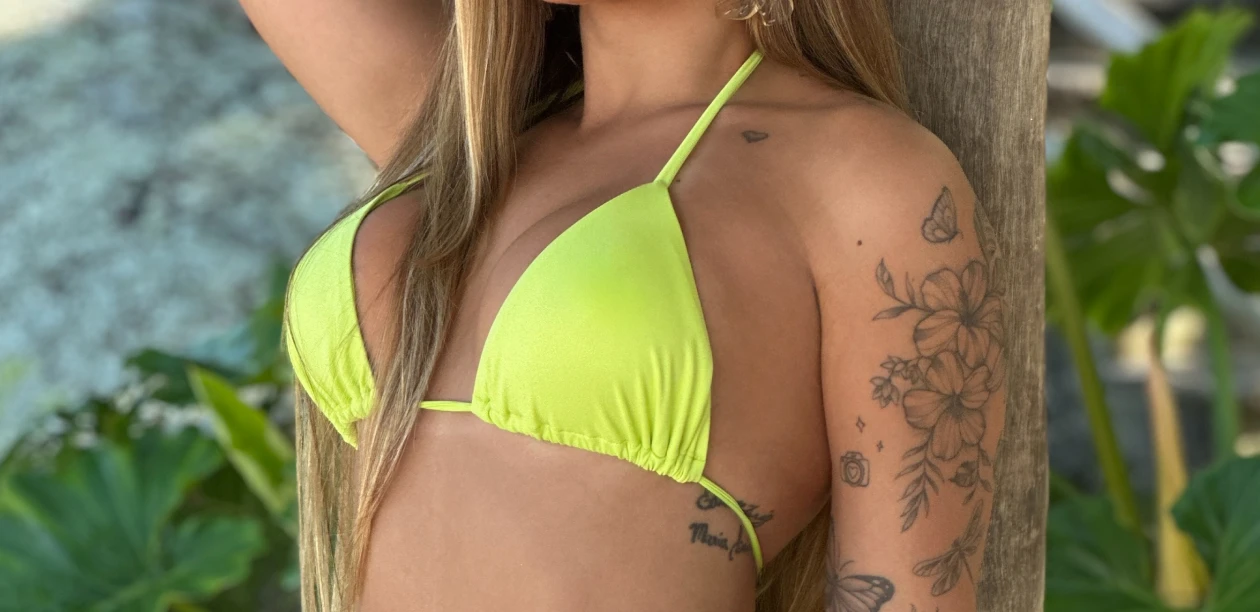 Modelo deitada na praia usando biquíni